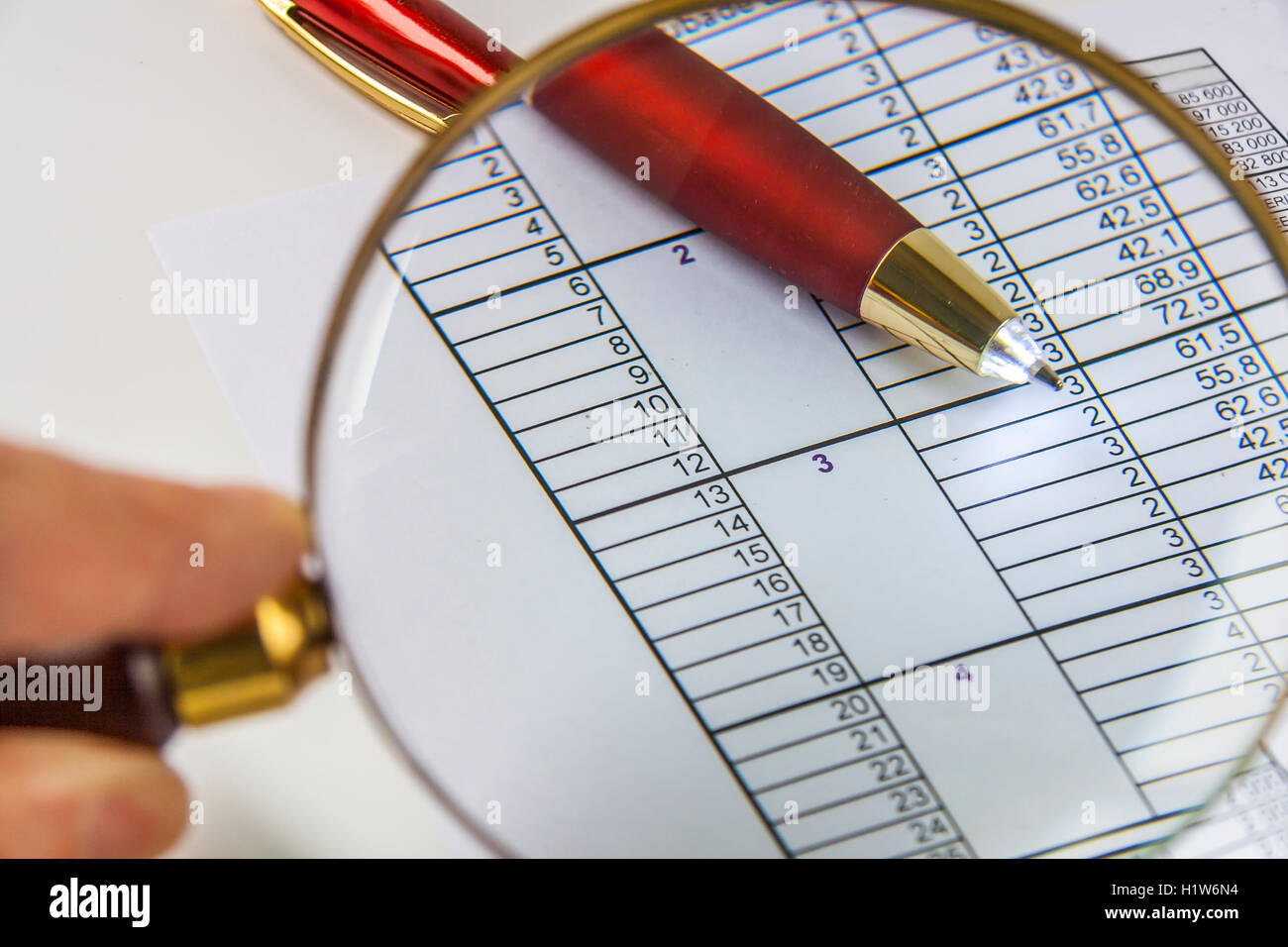 Magnifying glass in hand and working paper chart and pen Stock Photo ...
