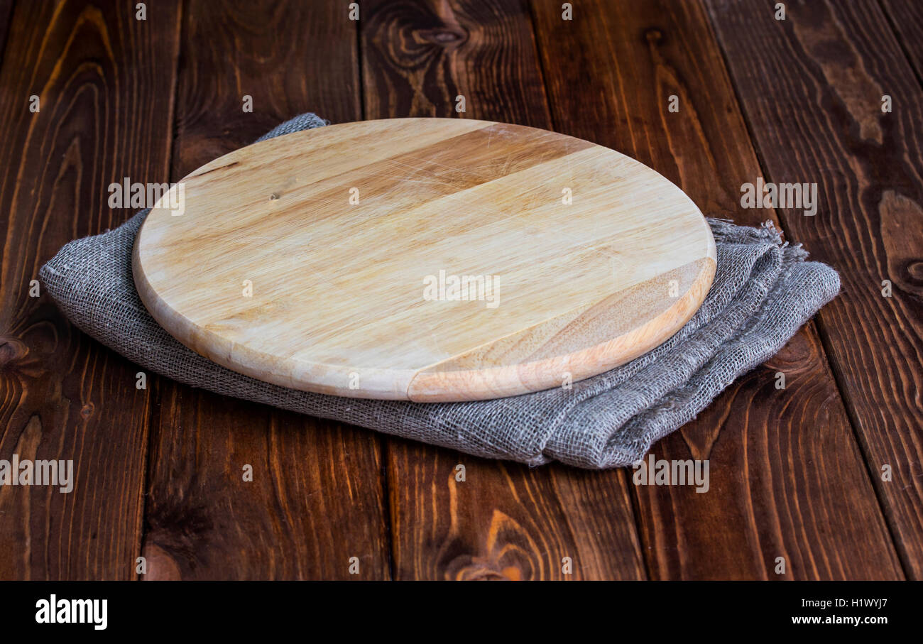Round chopping board on a wooden table Stock Photo