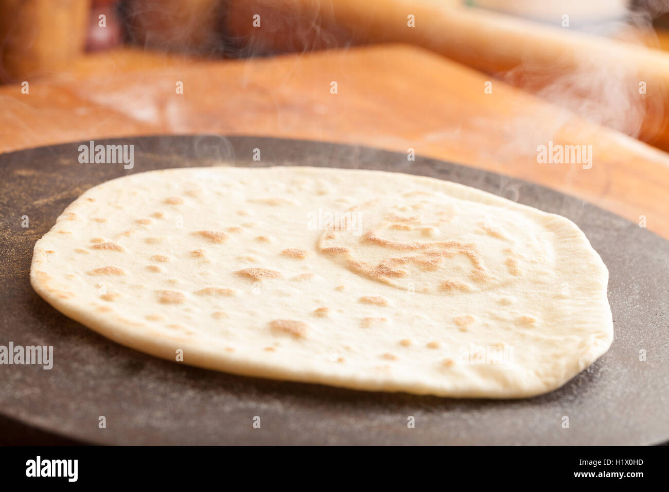 Cooking Flatbread on an iron hotplate Stock Photo