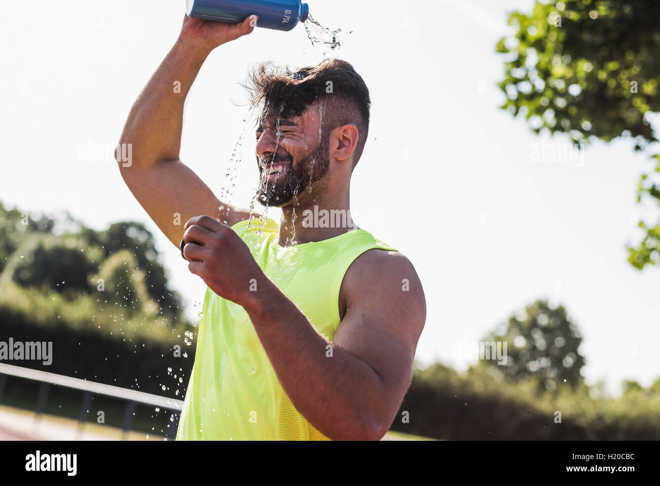 Athlete pouring water over his head Stock Photo Alamy