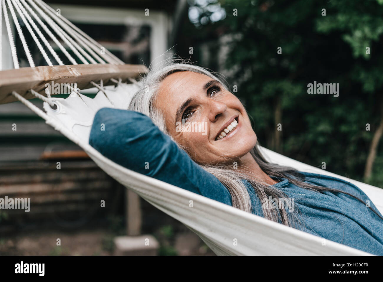 Portrait of smiling woman lying in hammock in the garden Stock Photo ...
