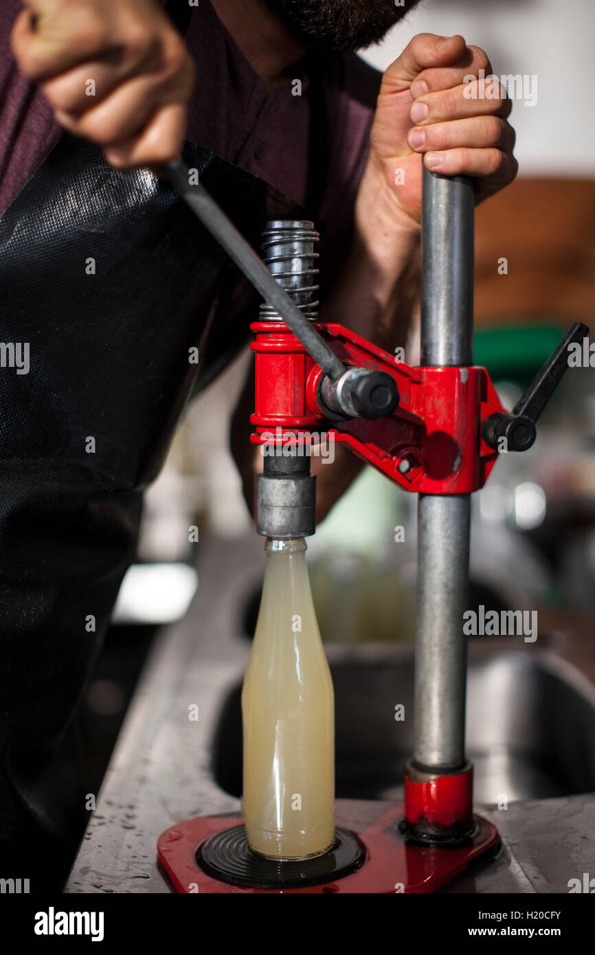 Man clamping lid on bottle of juice Stock Photo