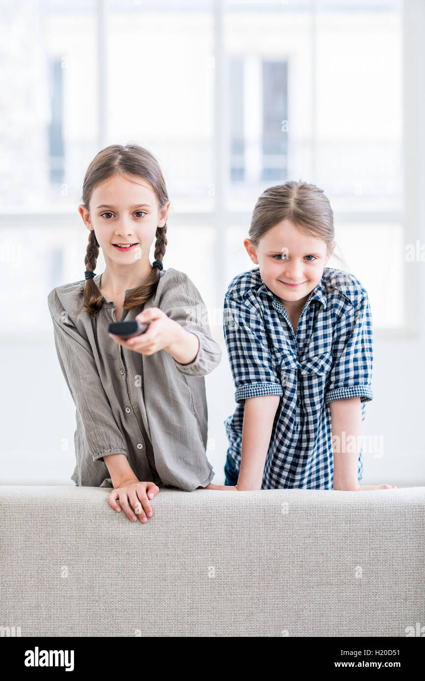 7 and 9 year-old girls watching TV. Stock Photo