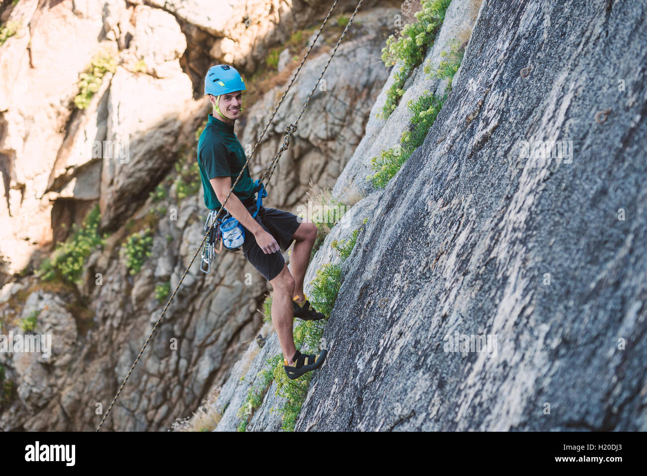 Young man climbing a rock wall Stock Photo