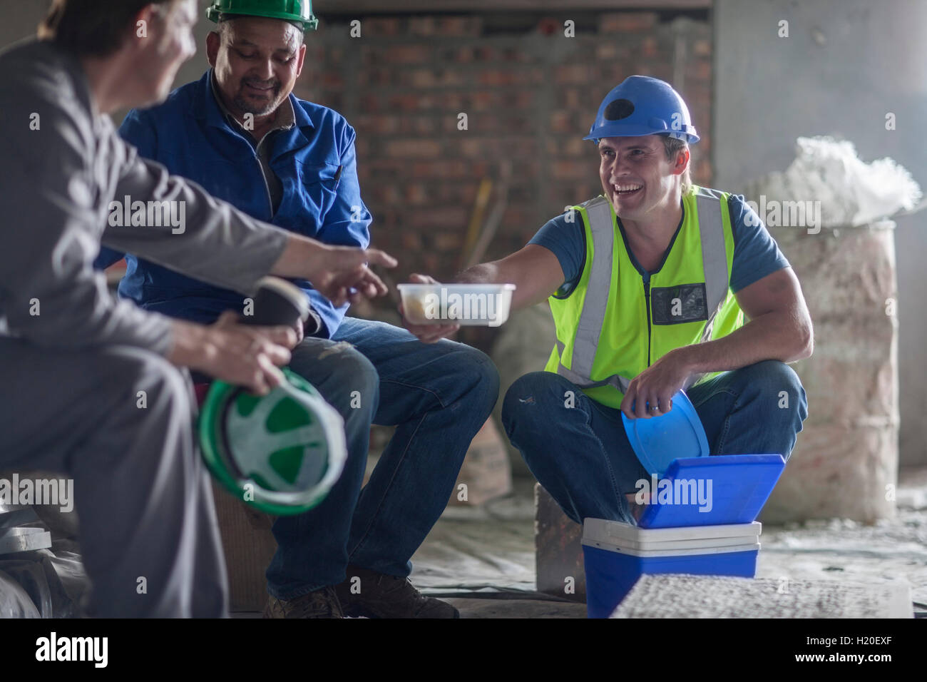 Three construction workers having lunch Stock Photo - Alamy
