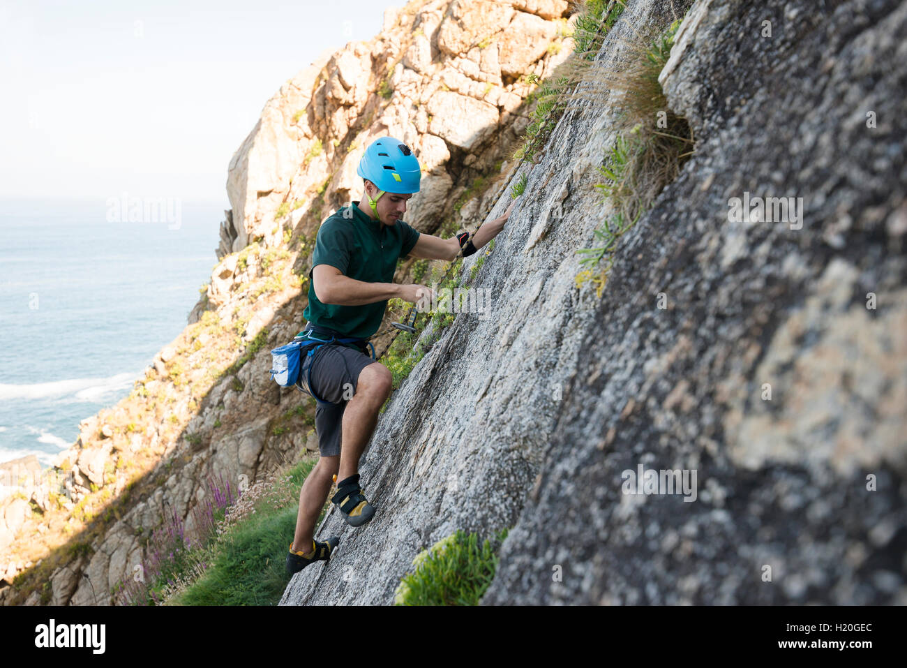 Young man climbing a rock wall Stock Photo