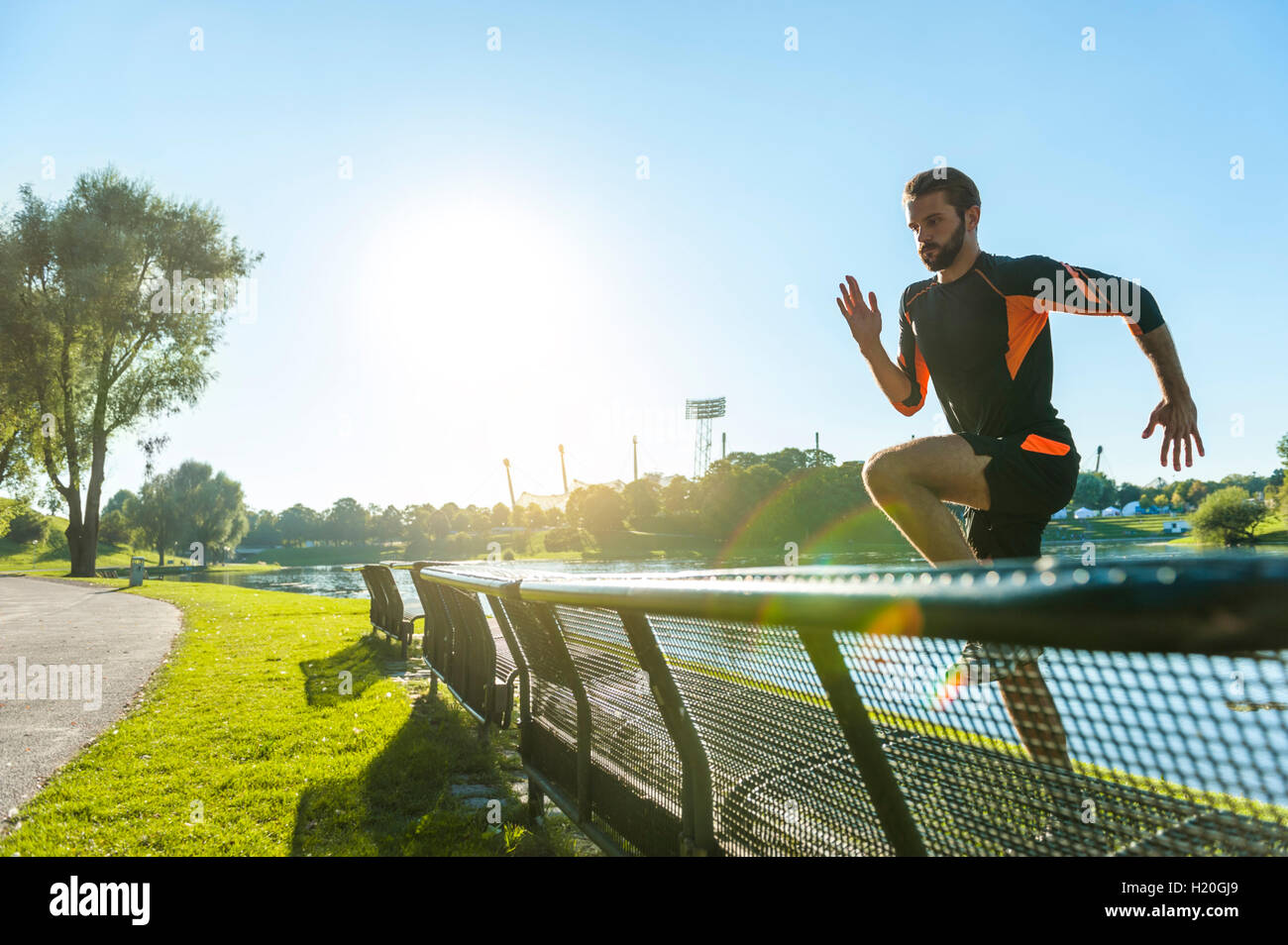 Athlete jumping over bench at the riverside Stock Photo Alamy