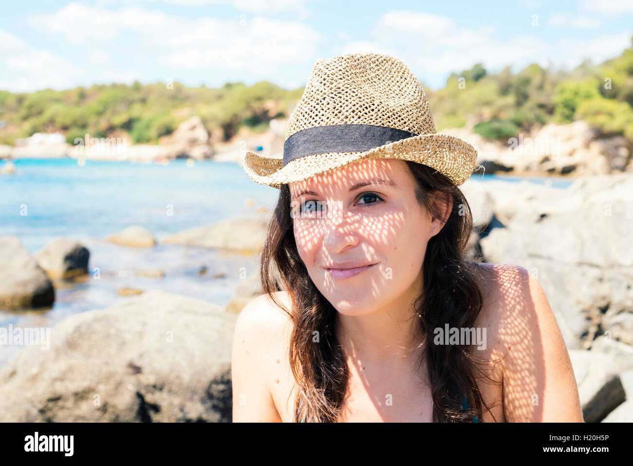 Portrait of smiling woman wearing straw hat on the beach Stock Photo ...