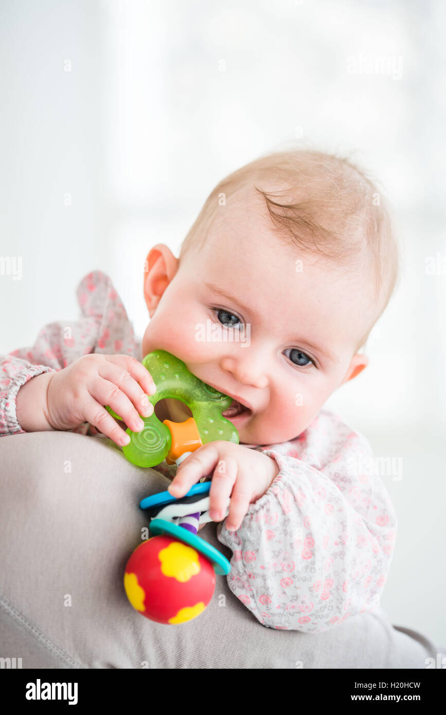 Teething 6 month old baby girl rubbing his gums when the first