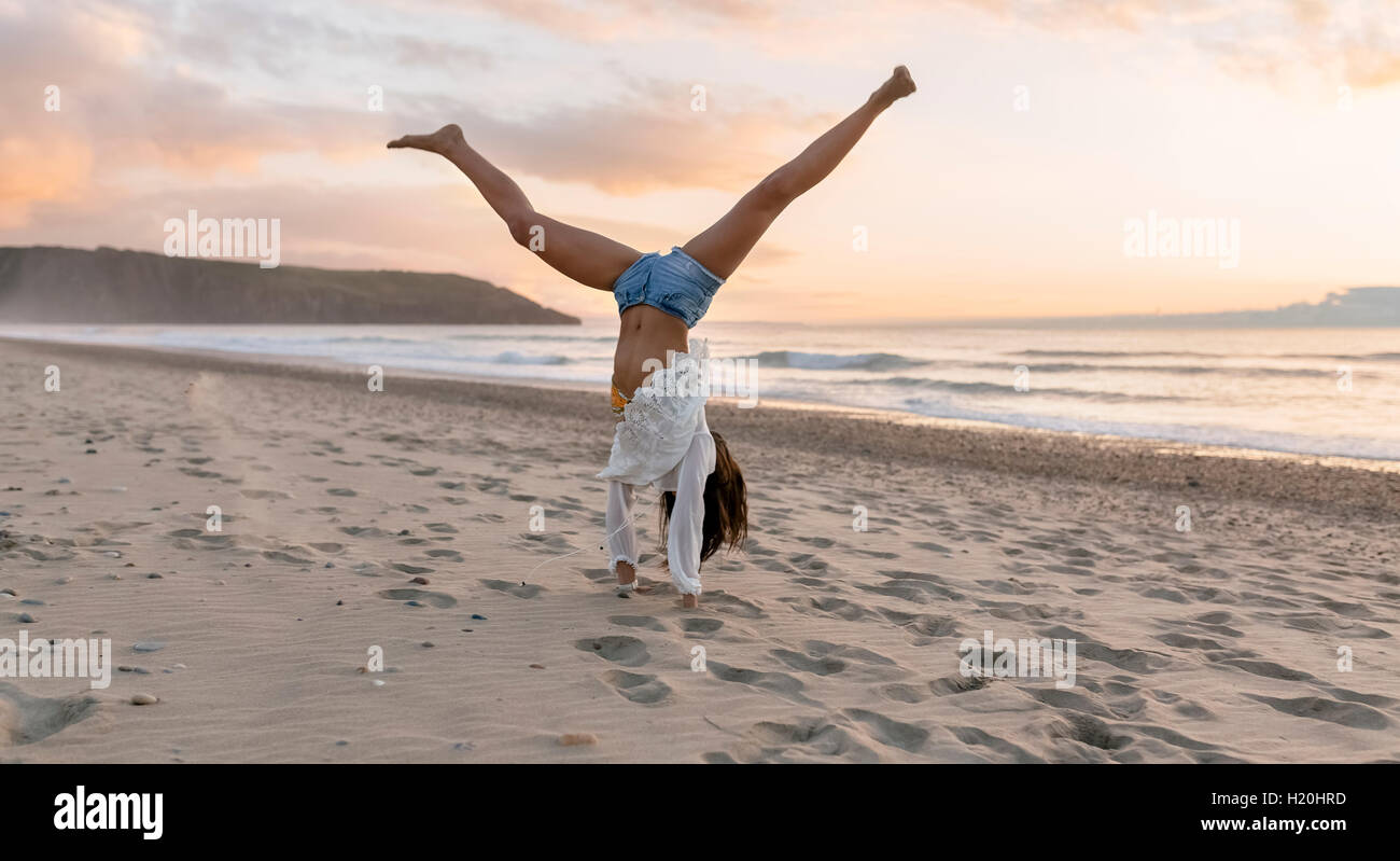 Spain, Asturias, beautiful young woman on the beach, turning wheels Stock Photo Alamy
