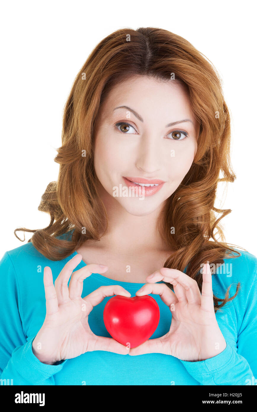 Attractive smiling woman showing red heart Stock Photo - Alamy