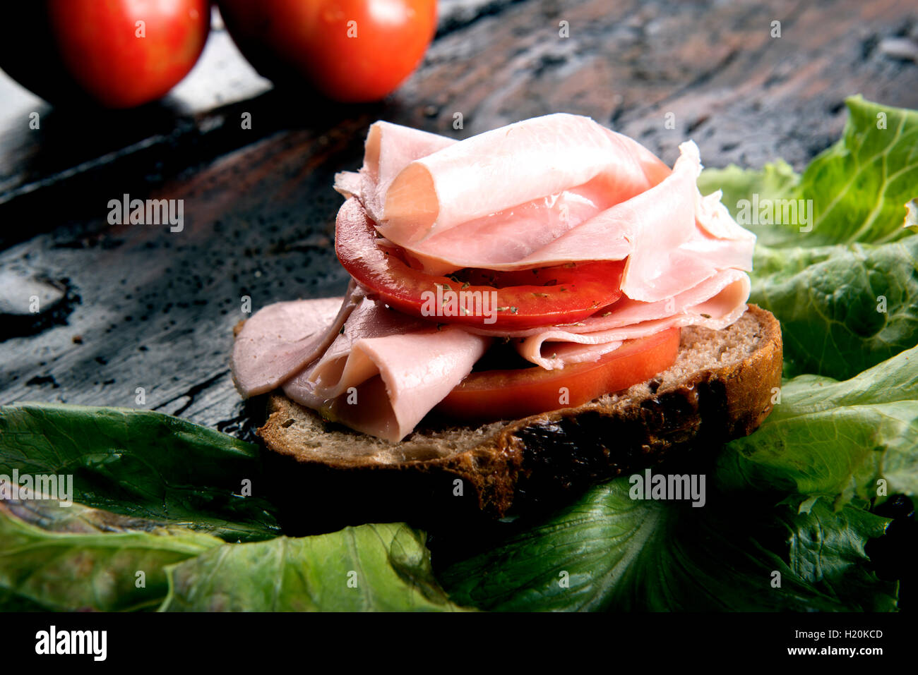 bruschetta with pork ham and tomato on a bread slice on wooden board Stock Photo