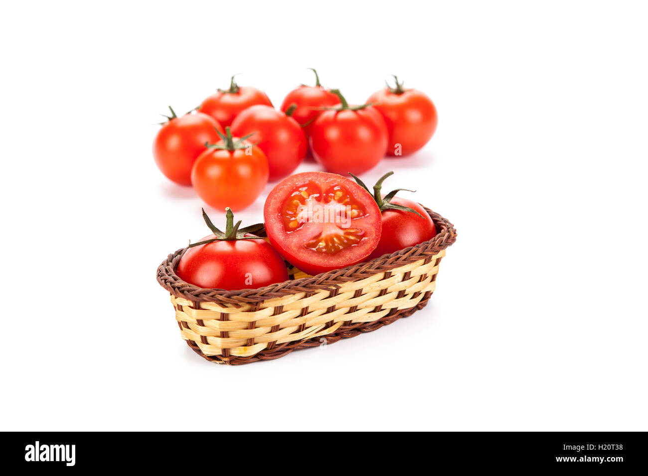 red tomatoes in a small basket on a white background Stock Photo - Alamy