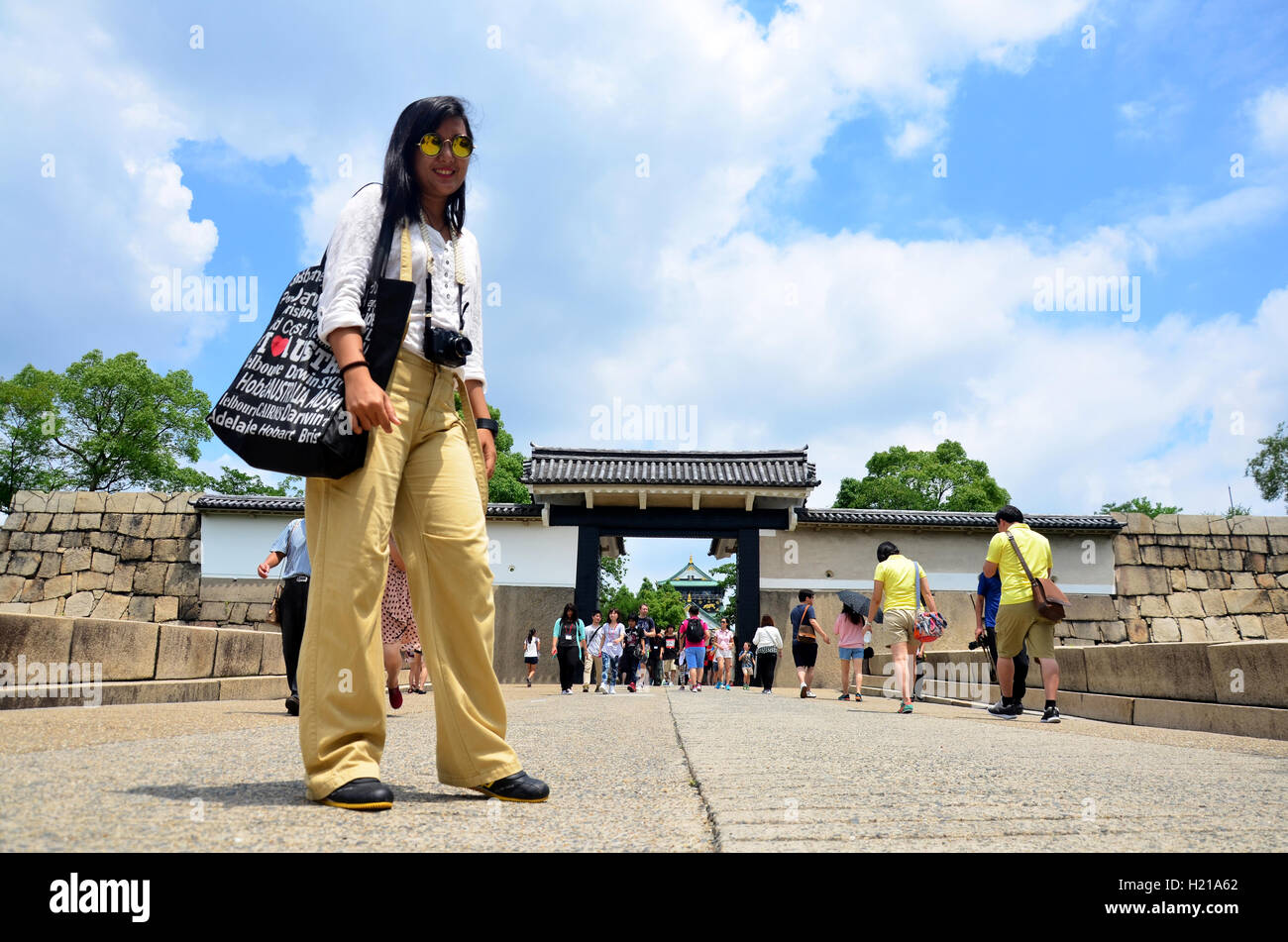 Traveller thai woman portrait at front of gate entrance to Osaka castle with traveler people walking to inside Osaka palace on J Stock Photo