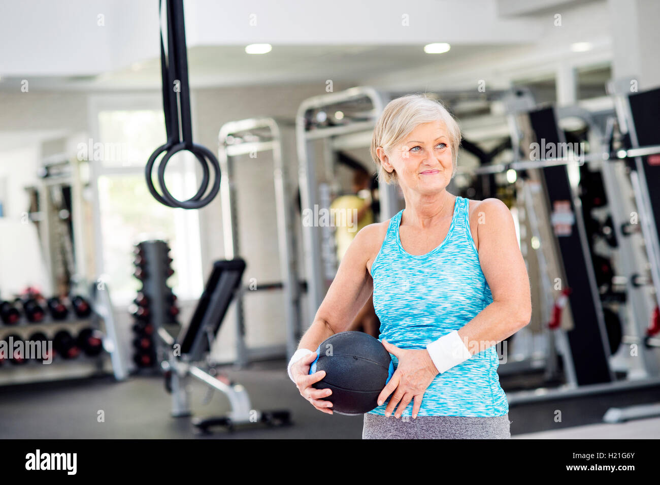 Mature woman holding ball in fitness gym Stock Photo - Alamy