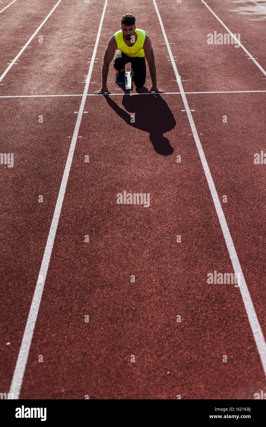 Runner on tartan track in starting position Stock Photo