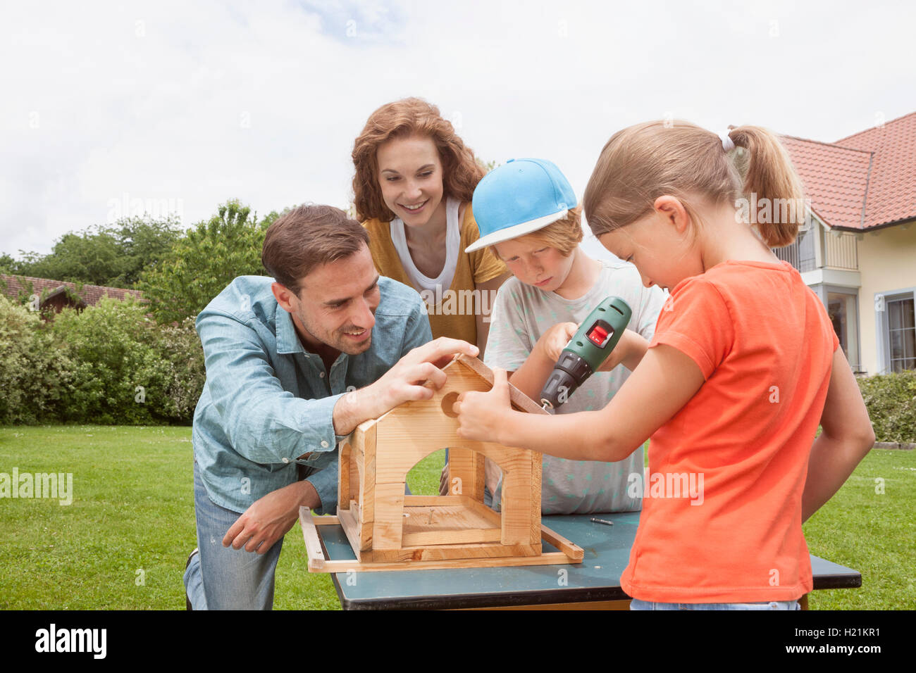 Family building up a birdhouse together Stock Photo - Alamy