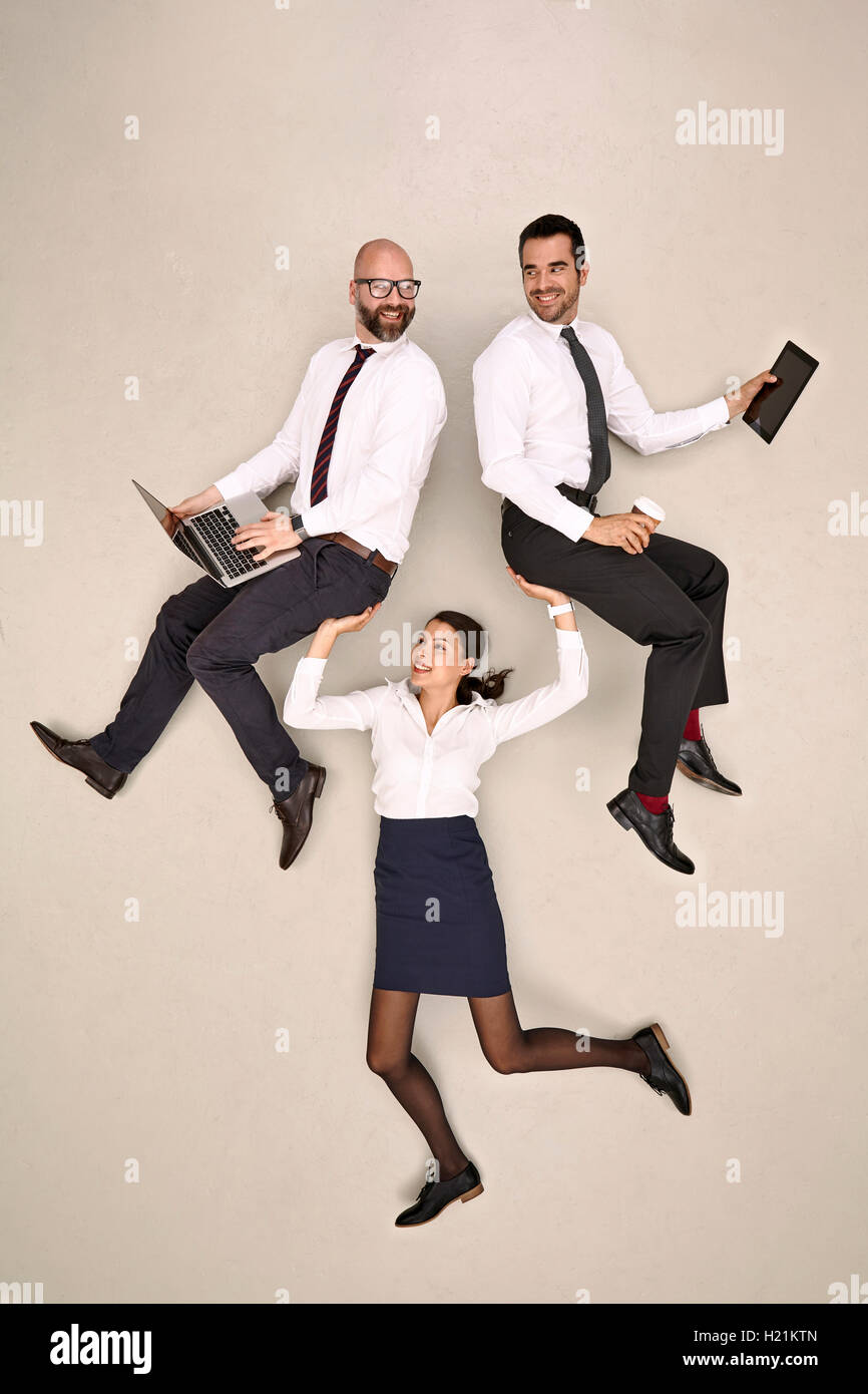 Businesswoman carrying her two male colleagues Stock Photo
