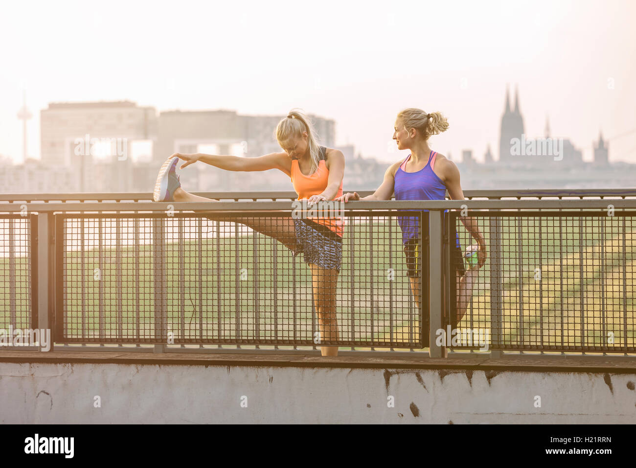 Two young women stretching on bridge Stock Photo