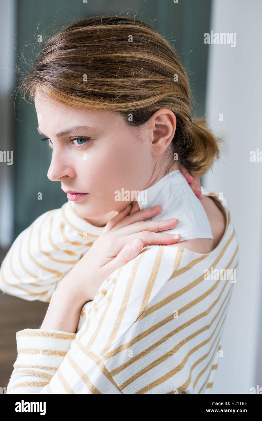 Woman applying heat patch for backache. Stock Photo