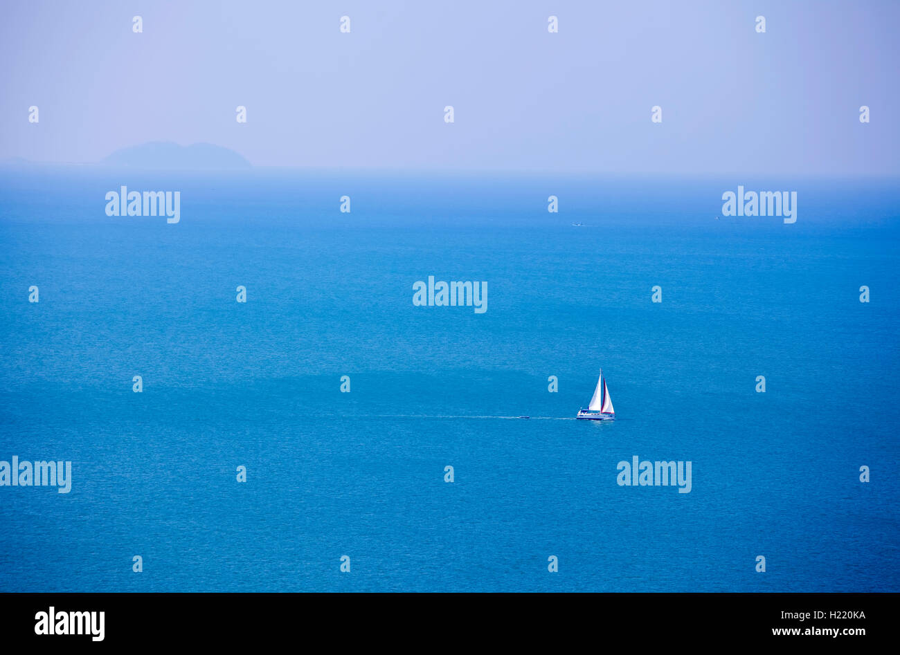 Beautiful blue ocean with white sailboat near horizon Stock Photo - Alamy