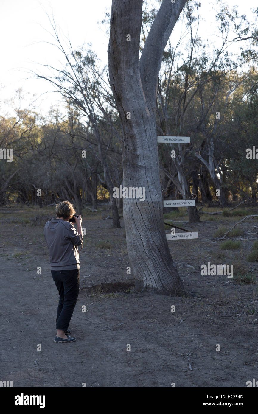 Tourist photographing flood sign at camp 31 Darling River Kinchega National Park New South Wales Australia Stock Photo