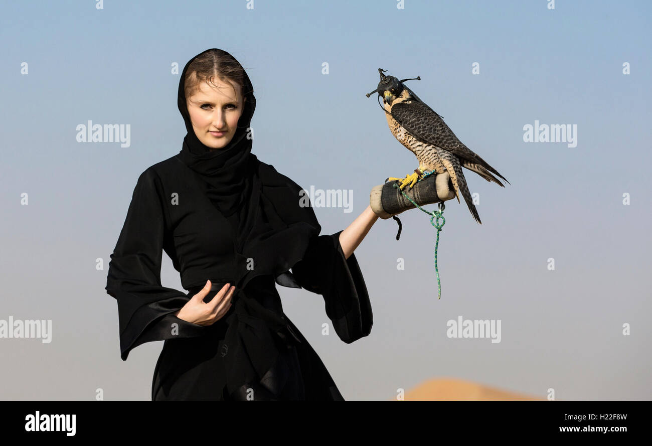 Emirati woman in traditional emirati dress abaya with a falcon