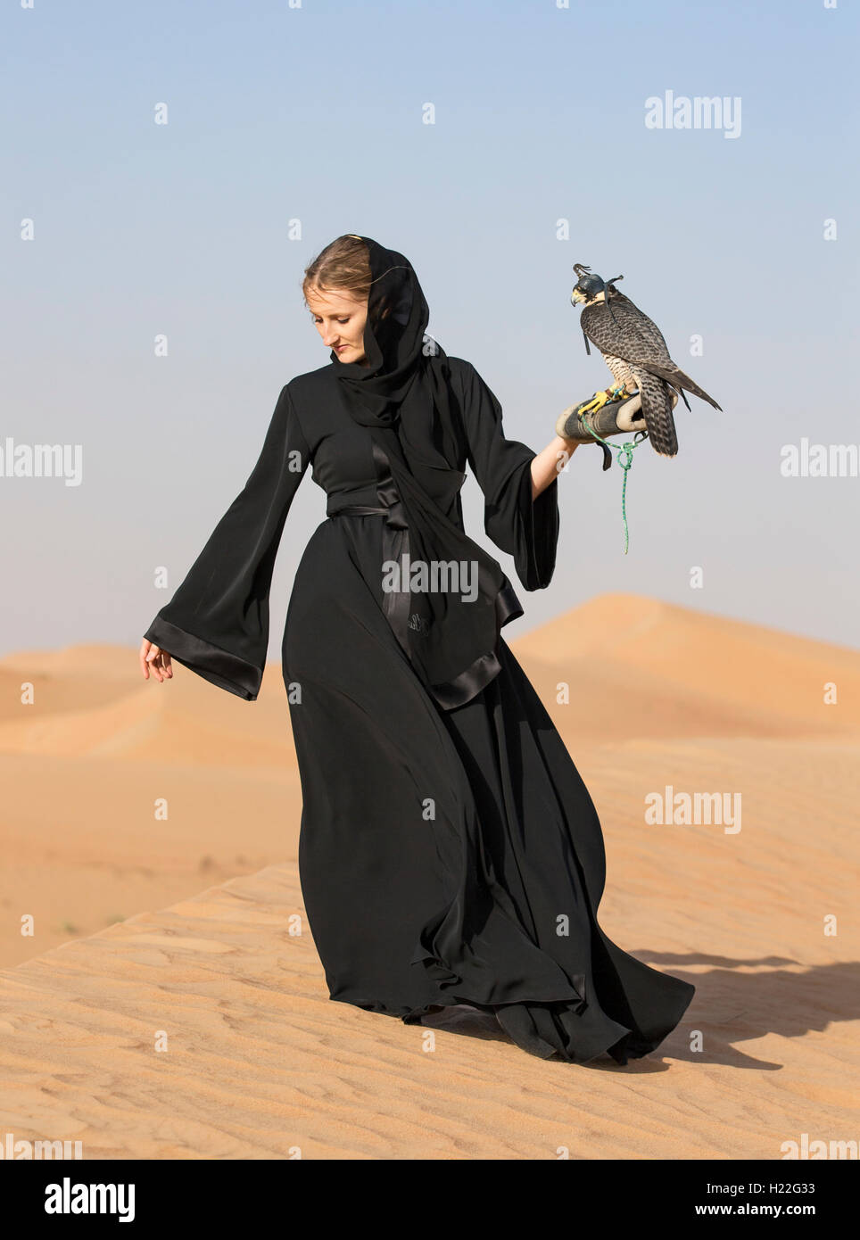 Emirati woman in traditional emirati dress (abaya) with a falcon Stock Photo