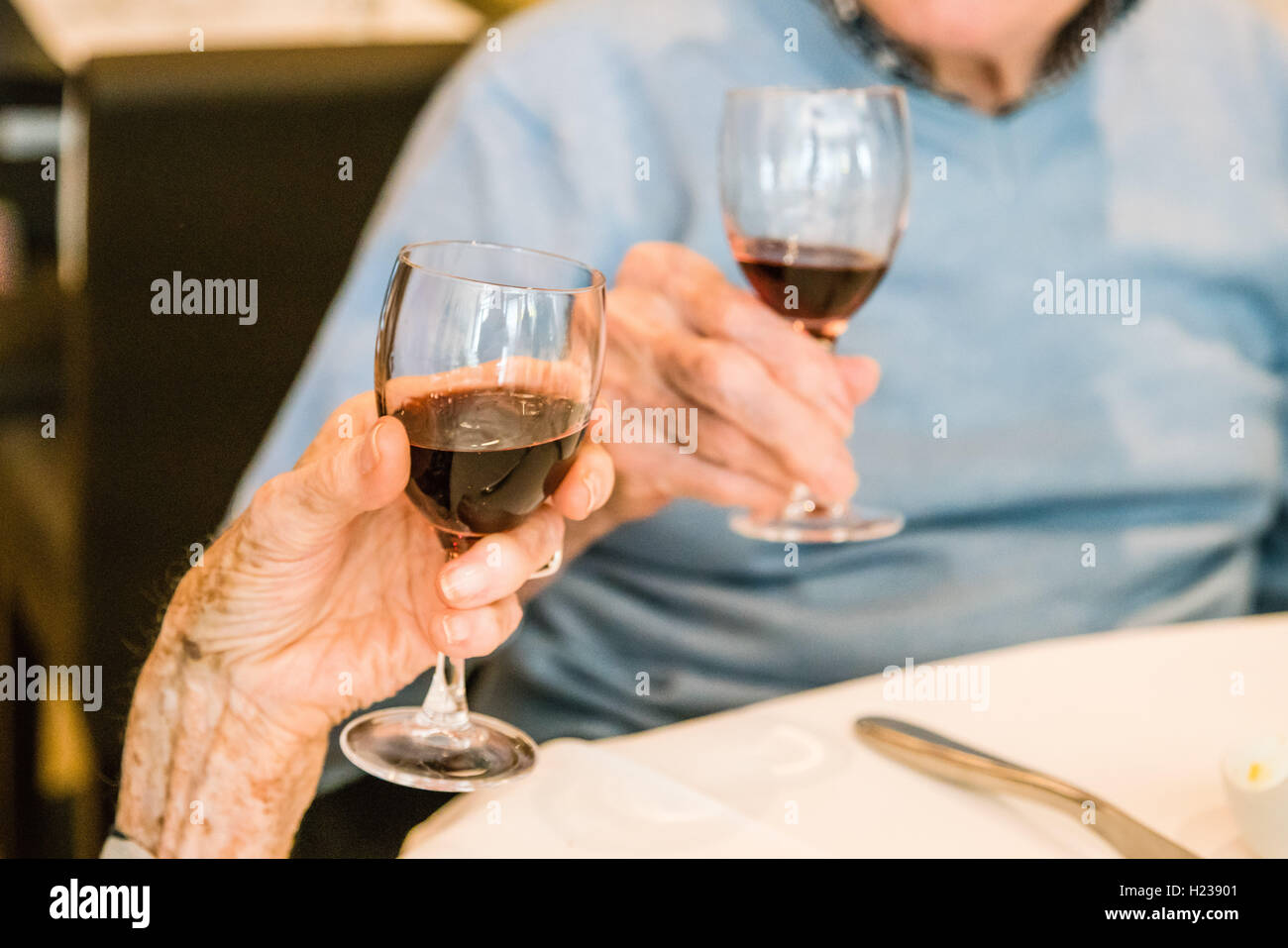Elderly couple drinking a glass of red wine. Stock Photo