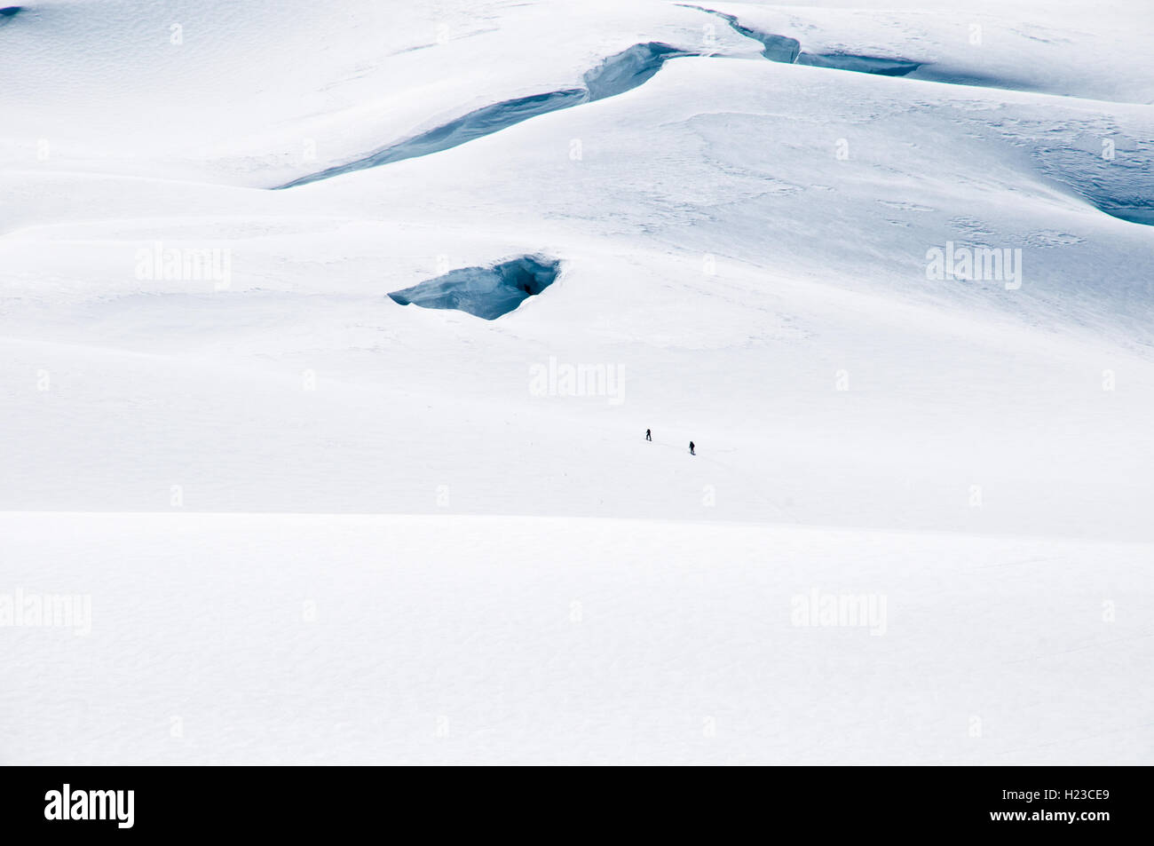 Two skiers trek near a crevasse in the icefields of the Saint Elias Mountains, in Kluane National Park, Yukon Territory, Canada. Stock Photo