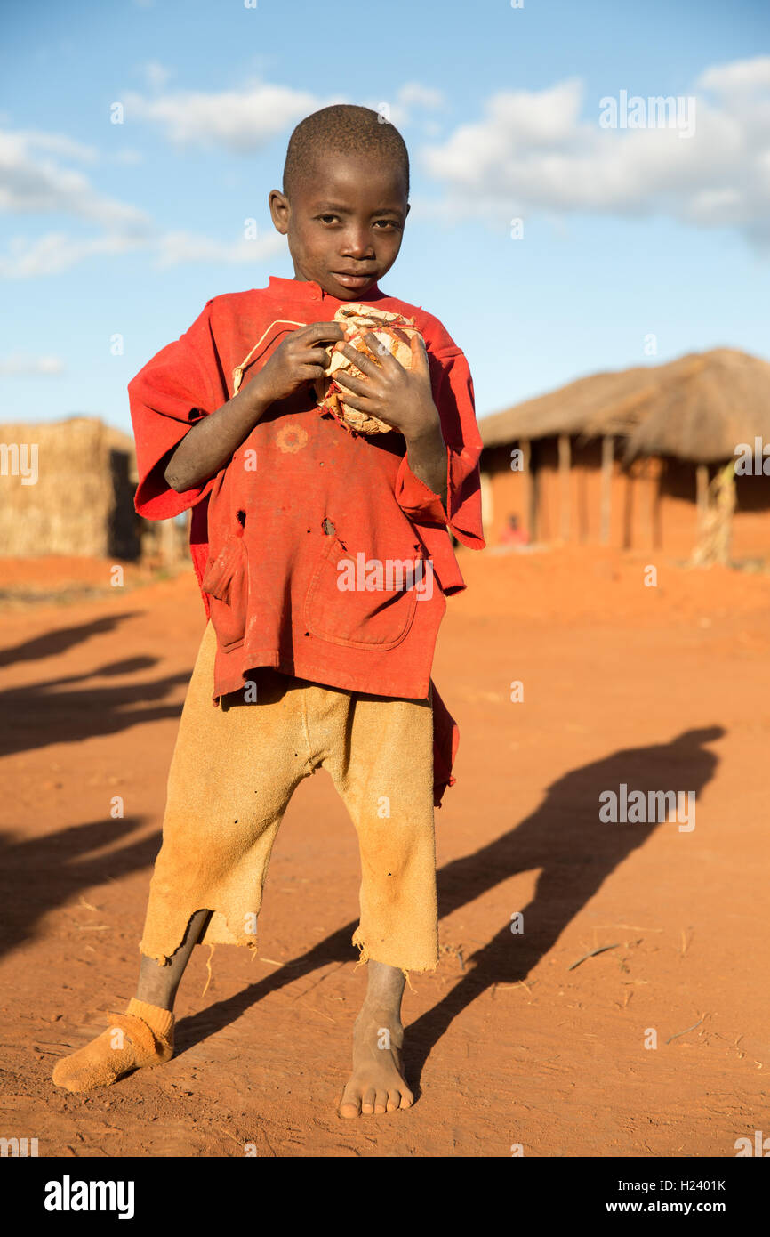 Namina village, Nampula Province, Mozambique, August 2015: A young boy holds a ball he hand his friends have been playing with. Stock Photo