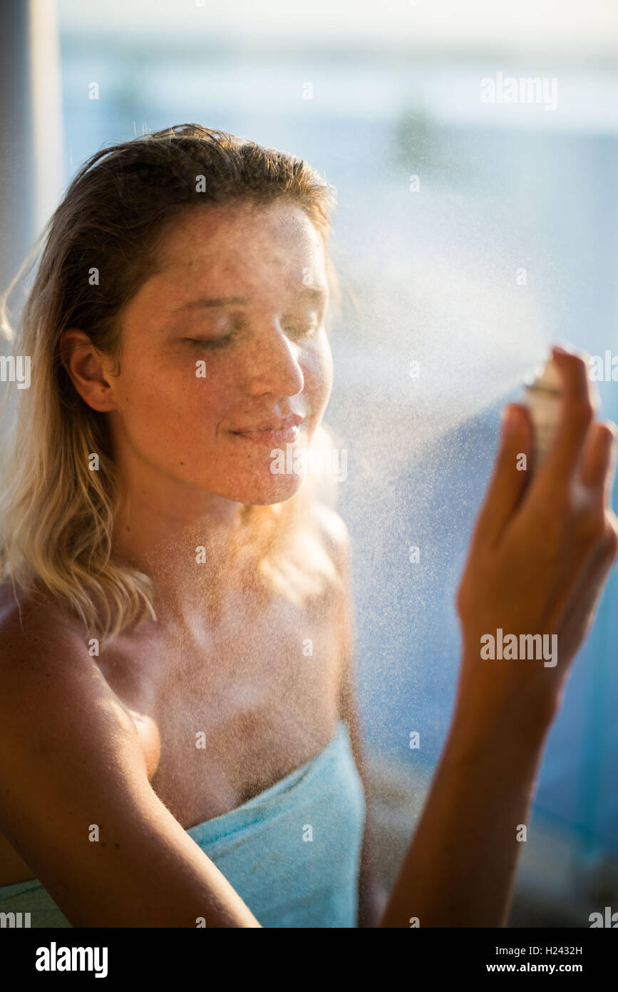 Woman spraying water on her face Stock Photo Alamy