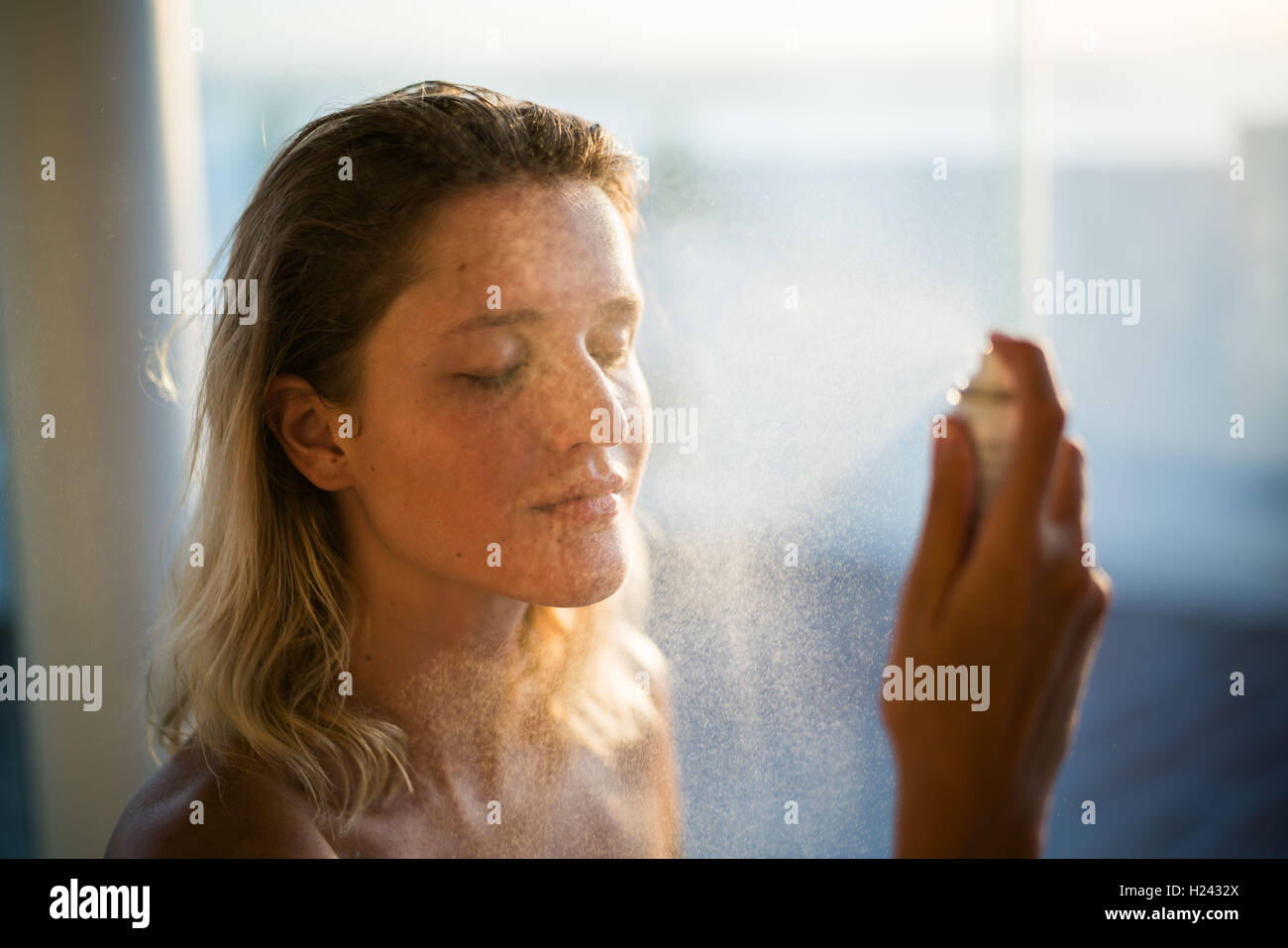 Woman spraying water on her face Stock Photo Alamy