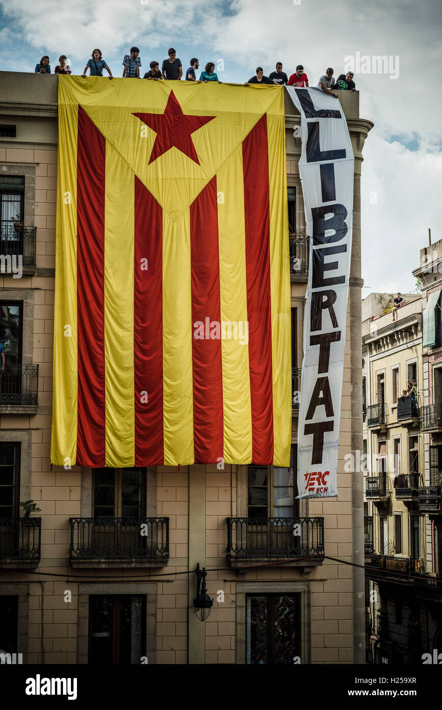 Barcelona, Spain. 24th September, 2016:  Pro-independence supporters hang a giant 'estelada' flag on the facade of a building facing the St Jaume Place demanding 'freedom' during the local 'Castellers' day at the Merce 2016 Credit:  matthi/Alamy Live News Stock Photo