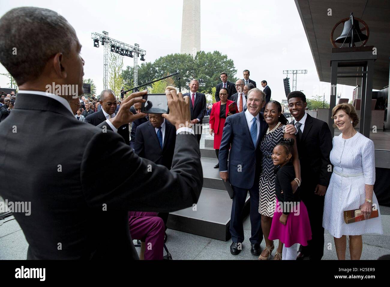 U.S.President Barack Obama takes a photo of former President George W. Bush, former First Lady Laura Bush and members of the Bonner Family following the opening of the Smithsonian National Museum of African American History and Culture September 24, 2016 in Washington, D.C. The Bonner Family are fourth generation descendants of Ellijah B. Odom, a young slave who escaped to freedom. Stock Photo
