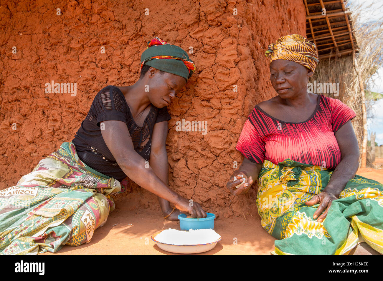 Namina village, Nampula Province, Mozambique, August 2015:  Maria Albino, 42, at home. She is blind with bilateral cataracts and needs help to do most tasks. Her sister Louisa makes a mid-day meal.  Photo by Mike Goldwater Stock Photo