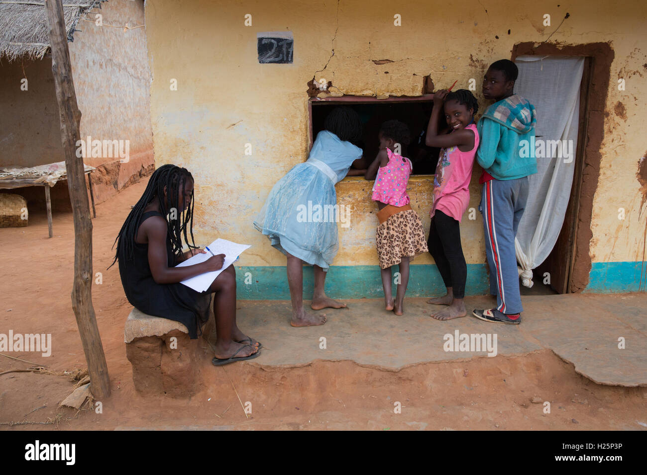 Ribaue,  Nampula Province, Mozambique, children queue and chat at the window of a local shop after school. Stock Photo