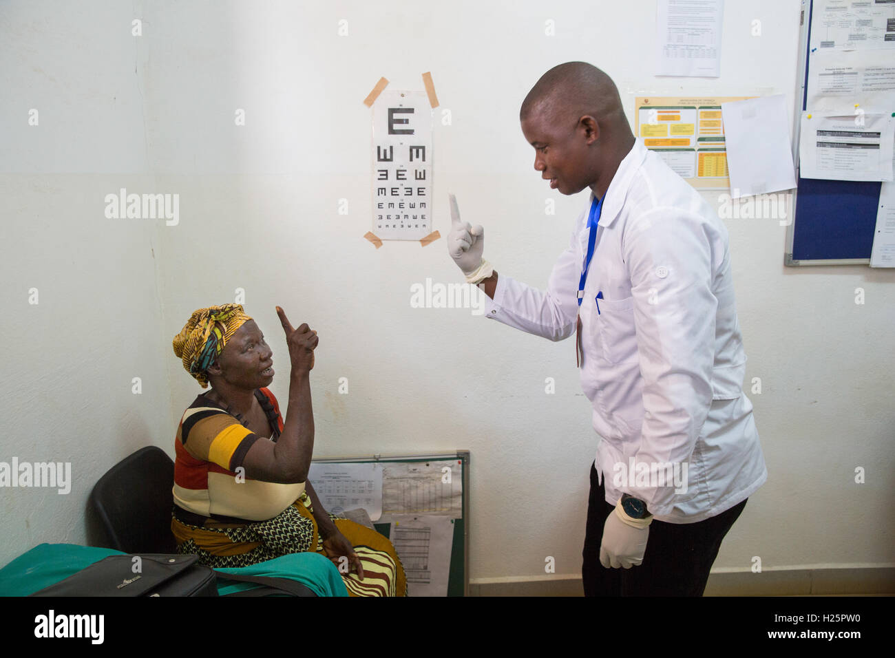 Ribaue Hospital, Ribaue,  Nampula Province, Mozambique, August 2015: Ophthalmic Technician Domingos Geraldo tests Maria Albino's sight after removing the bandage from  eye following her cataract operation the day before.  Photo by Mike Goldwater Stock Photo