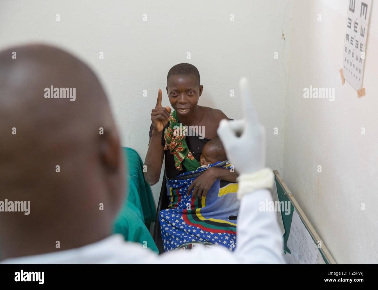 Ribaue Hospital, Ribaue,  Nampula Province, Mozambique, August 2015: Ophthalmic Technician Domingos Geraldo tests Laurinda Diago's sight after the cataract operation on her second eye the day before.  Photo by Mike Goldwater Stock Photo