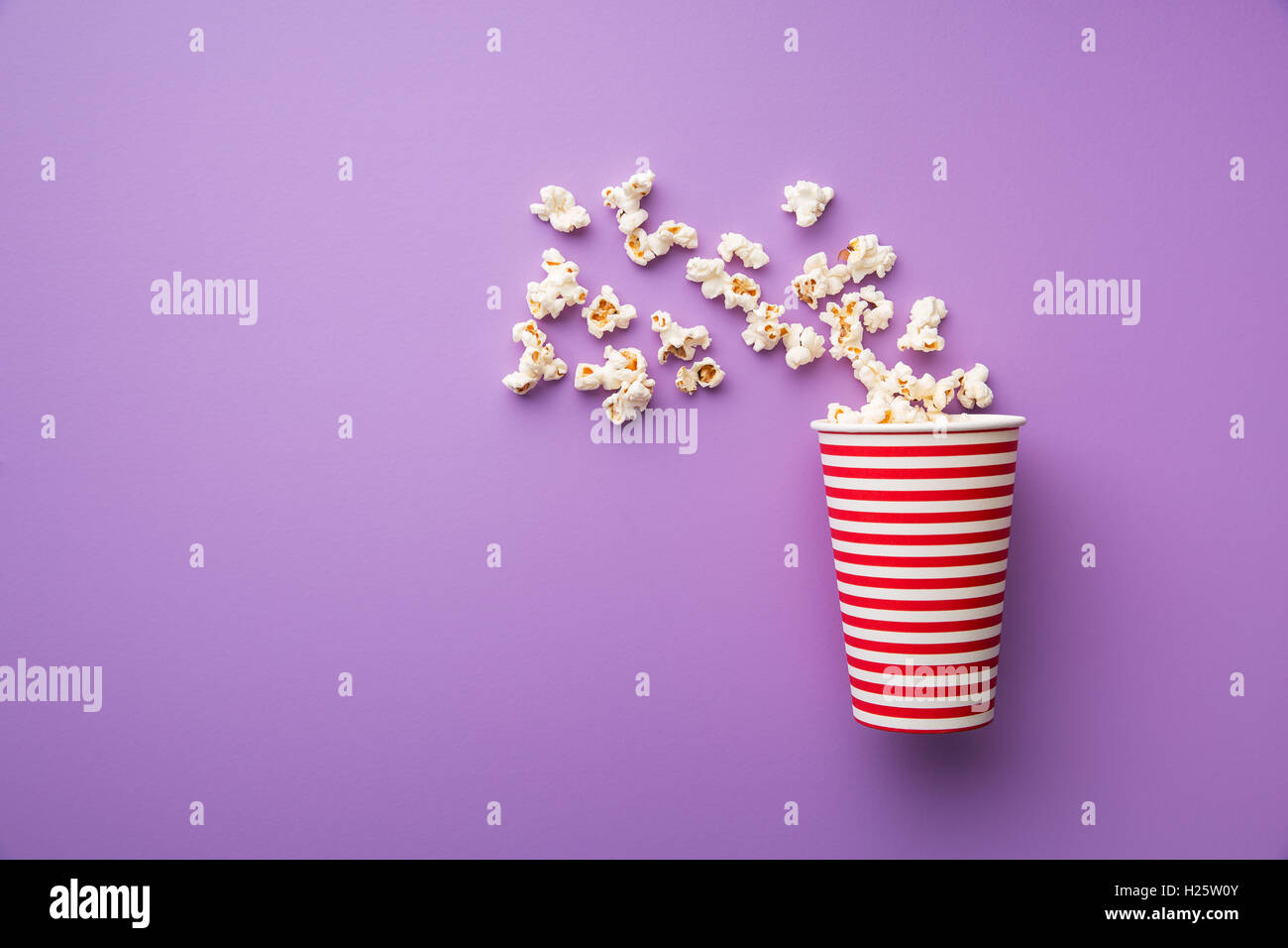 Popcorn in paper cup on colorful background Stock Photo - Alamy