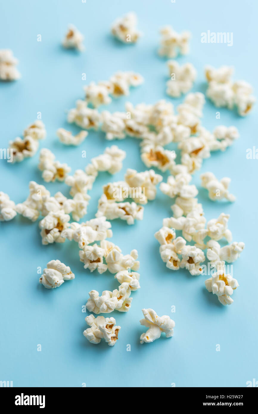 Tasty popcorn on blue background. Stock Photo