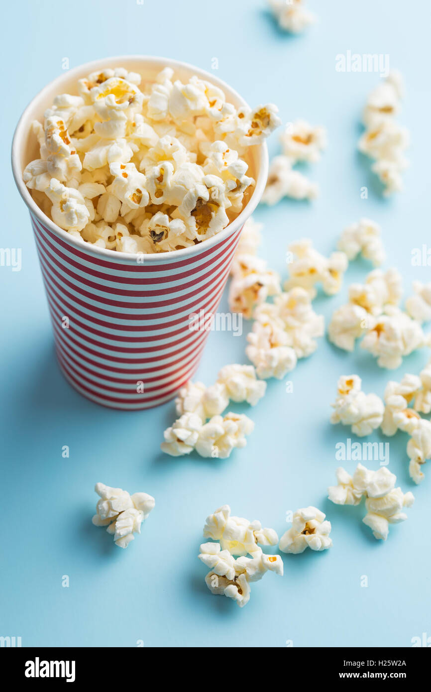 Popcorn in paper cup on colorful background Stock Photo - Alamy