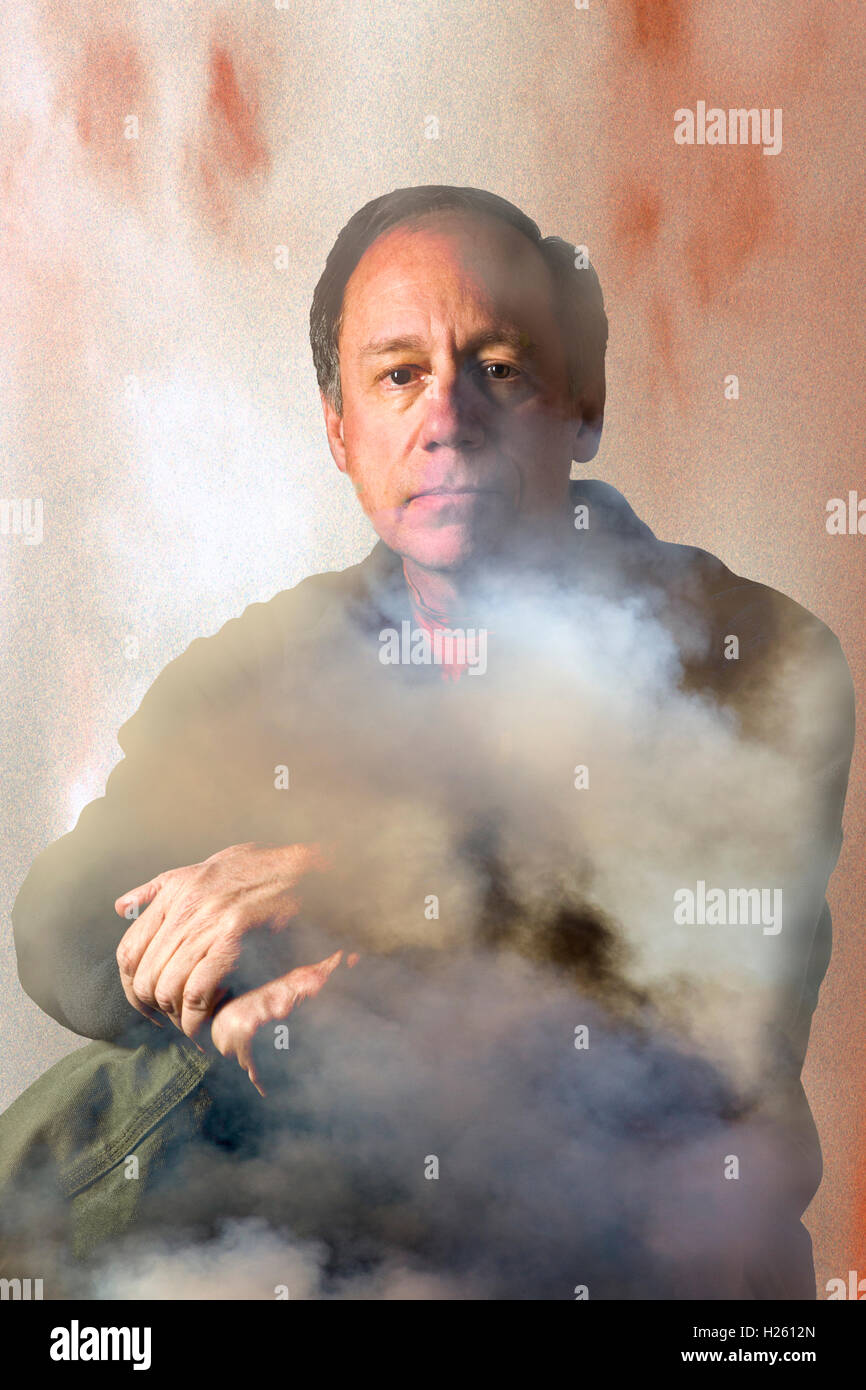 Mysterious smoky studio portrait of middle aged man Stock Photo