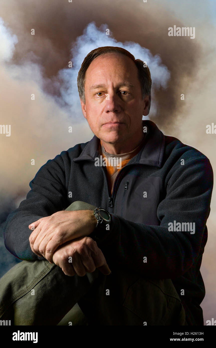 Mysterious smoky studio portrait of middle aged man Stock Photo