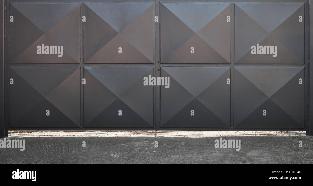 Closed black metal gate with square relief pattern Stock Photo