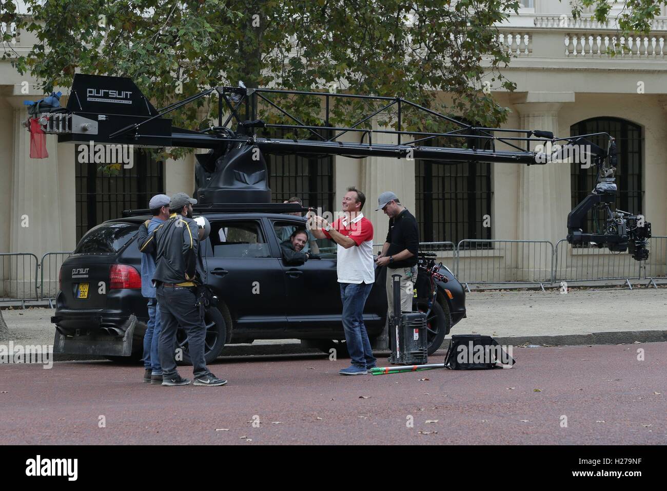 People take pictures next to a car camera rig during filming of the film Transformers: The Last Knight, on The Mall in London. Stock Photo