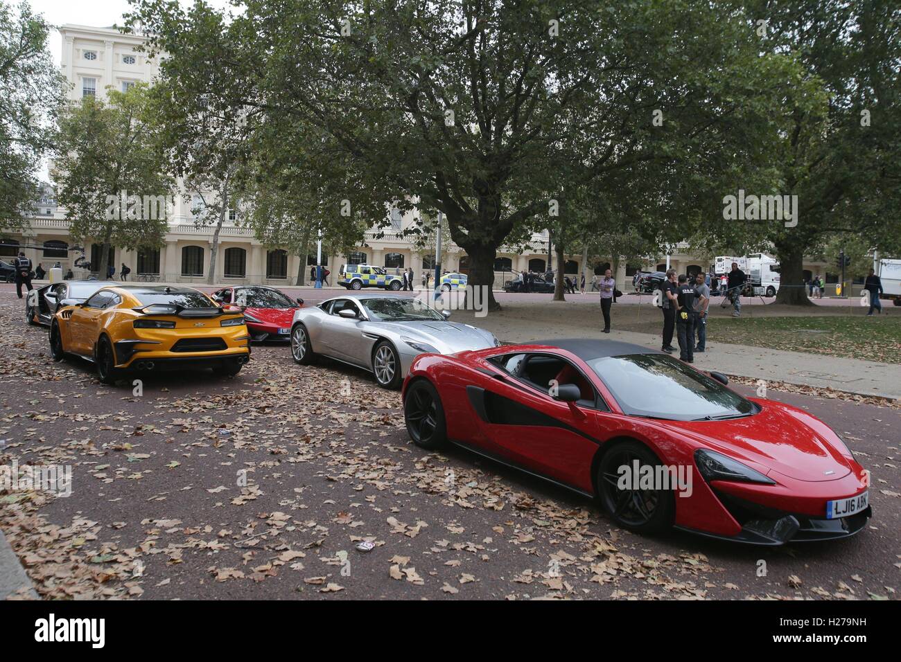 A Chevrolet Camaro (left in yellow), Aston Martin DB11 (centre in silver) and a McLaren (right in red) sports car during filming of the film Transformers: The Last Knight, on The Mall in London. Stock Photo