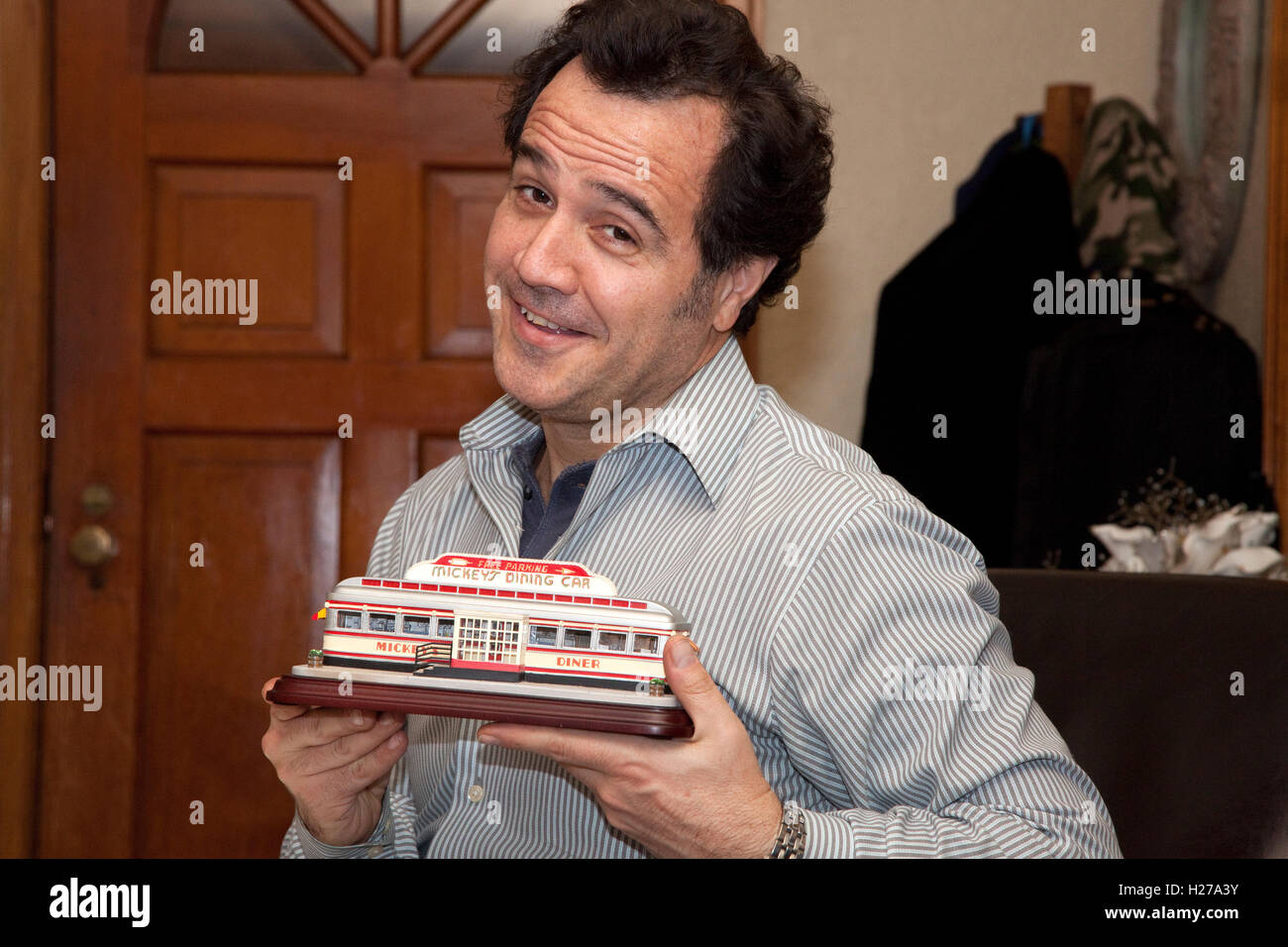 Man age 48 holding a replica of Mickey's diner in his hands. St Paul Minnesota MN USA Stock Photo