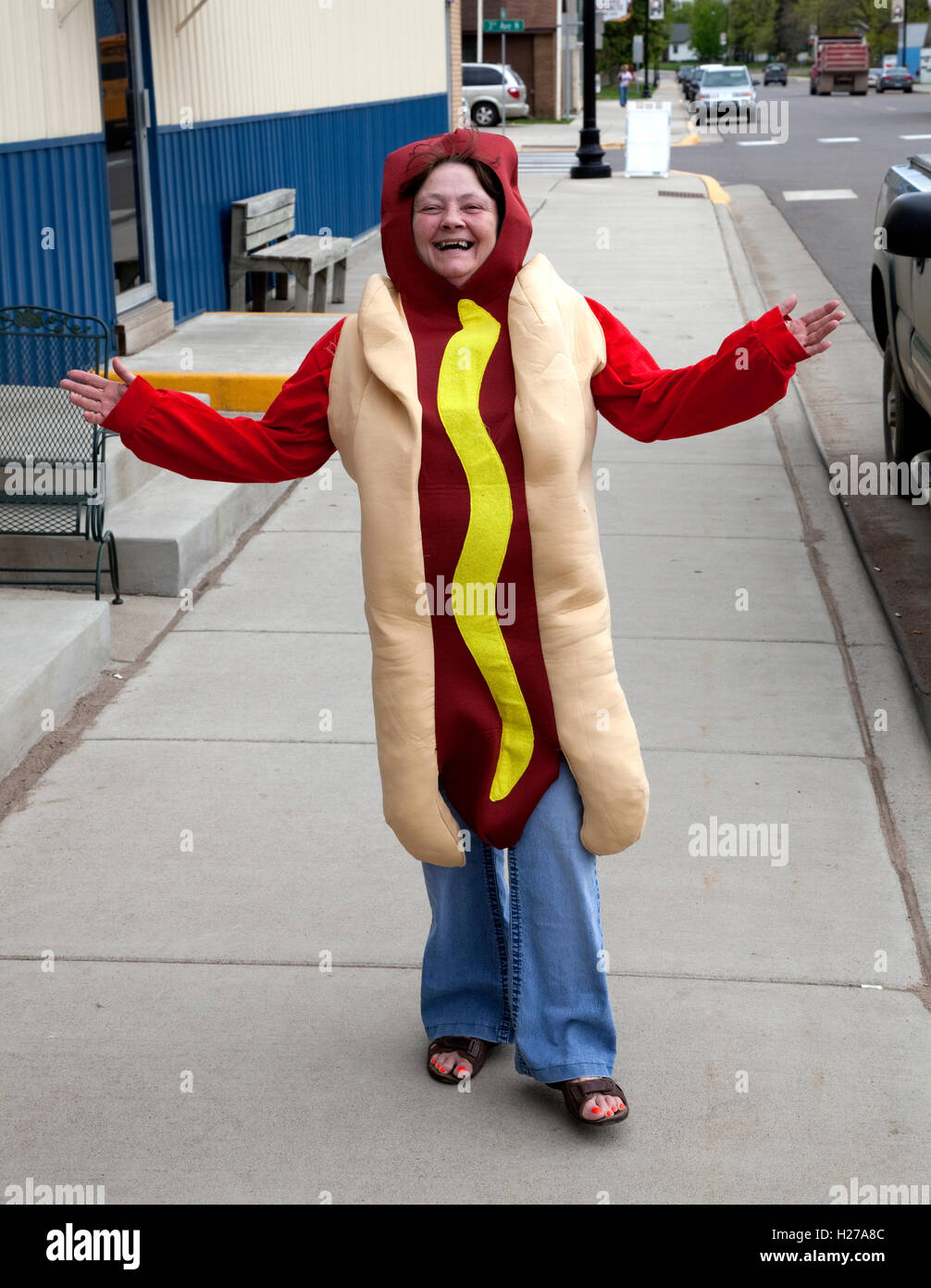 Woman in a hot dog or brat costume with a stripe of mustard advertising an outdoor barbecue grill. Pierz Minnesota MN USA Stock Photo