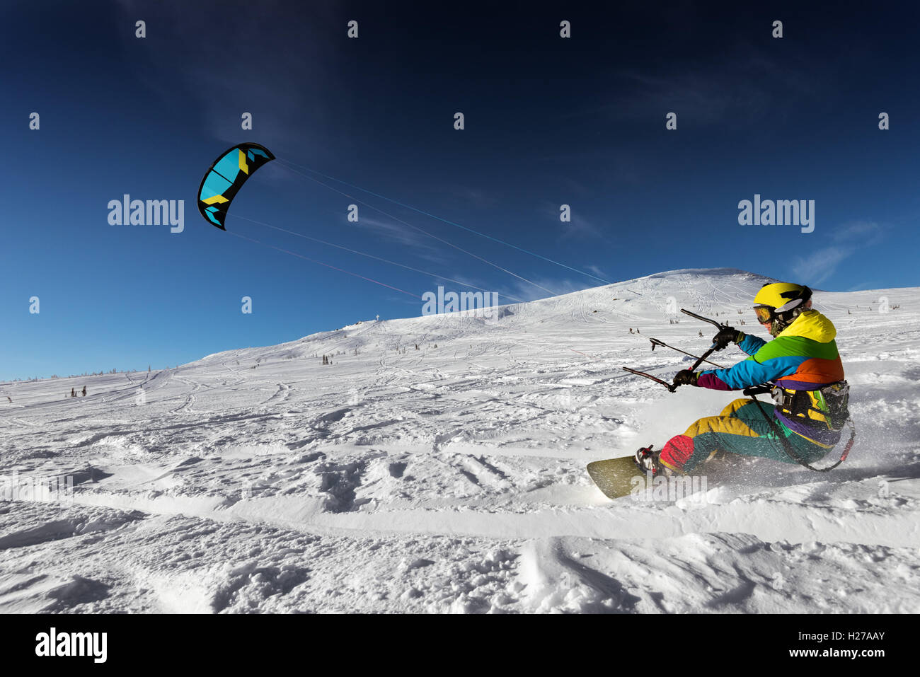 Snowboarder skydives on blue sky backdrop in snow mountains Stock Photo